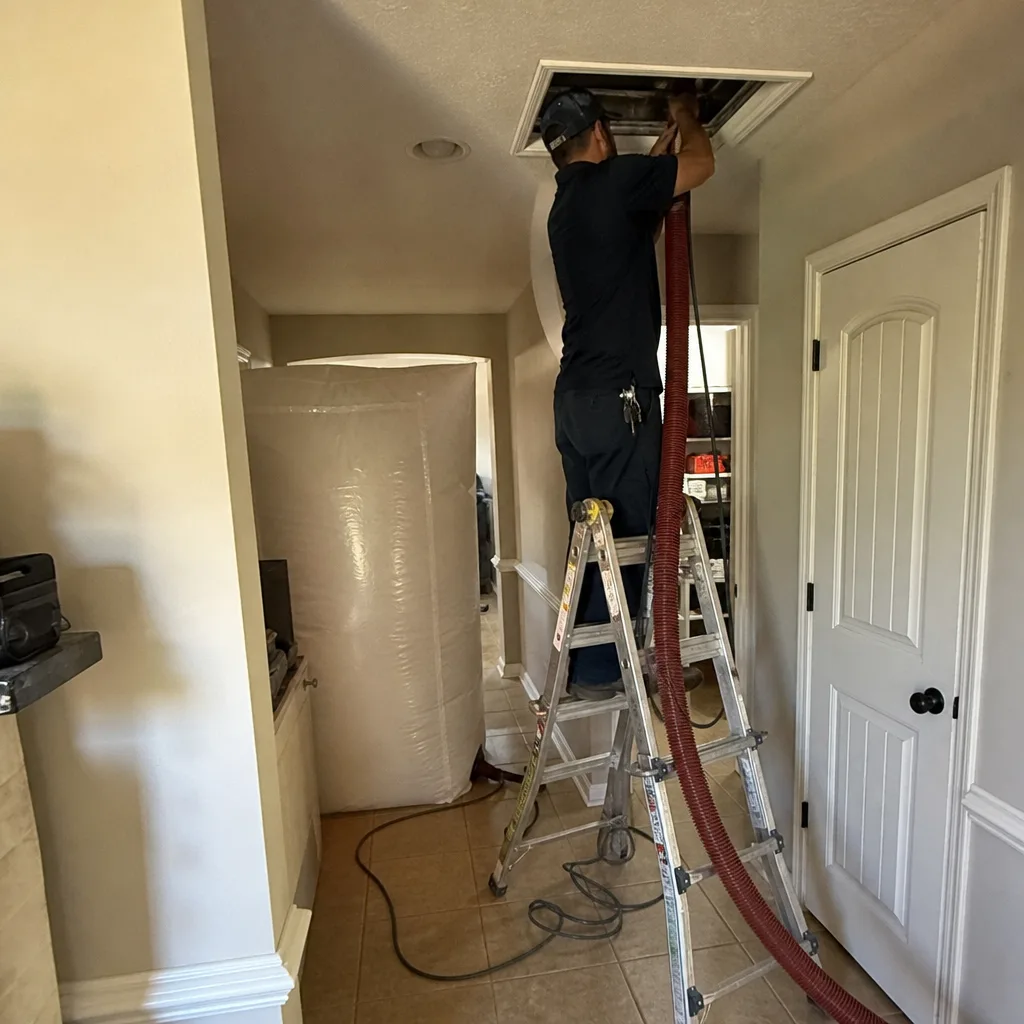 Technician performing professional residential air duct cleaning service