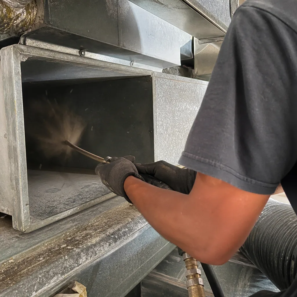 Technician using professional equipment for thorough residential air duct cleaning service.